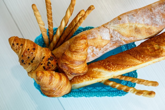 A basket with fresh pastries, croissants and bread. Whole grain baked goods, yeast-free bread