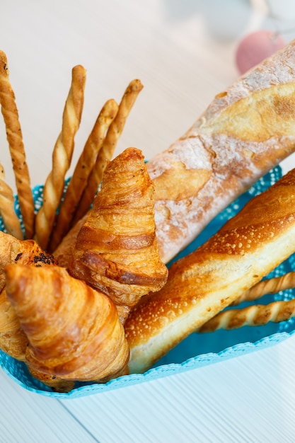 A basket with fresh pastries, croissants and bread. Whole grain baked goods, yeast-free bread