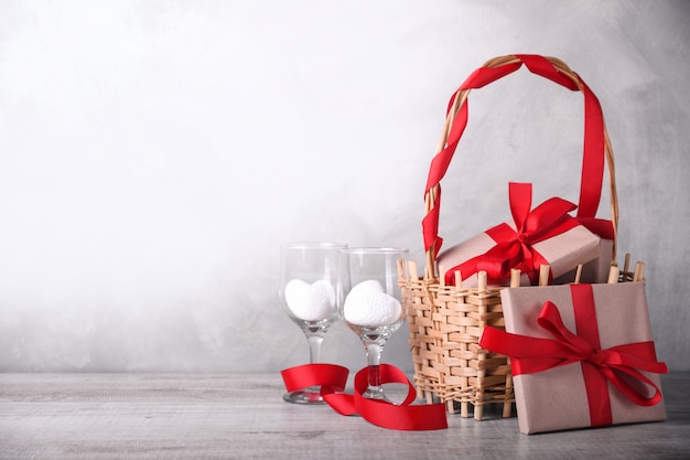 Basket with gifts and two wine glasses