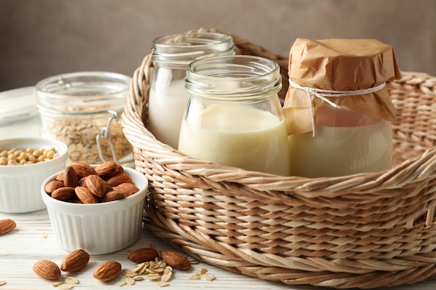 Basket with a glasses of different types milk on wooden