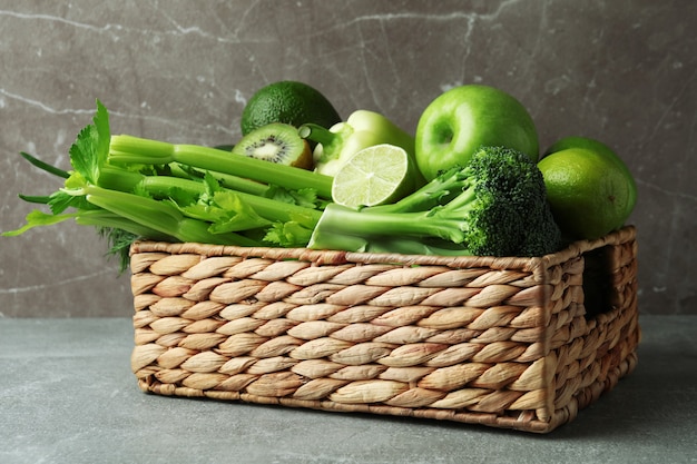 灰色のテーブルに緑の野菜とバスケット