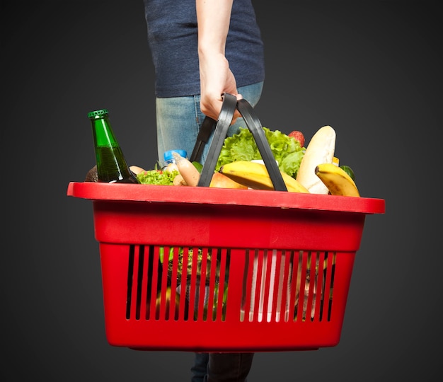 Foto cestino con generi alimentari in mano della donna