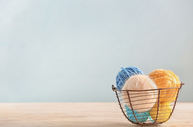 Basket with knitting yarn on table with copy space