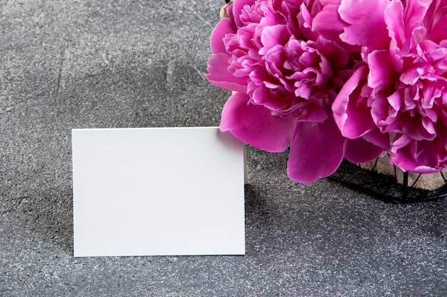 Basket with pink peonies and blank note 