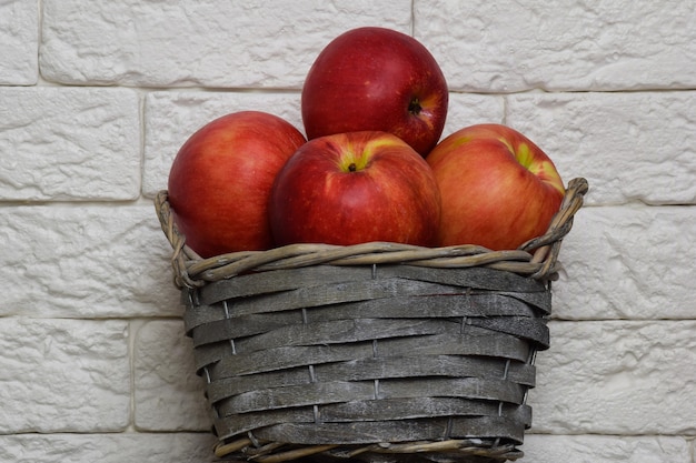 벽돌 빛 벽의 배경에 빨간 사과 바구니.