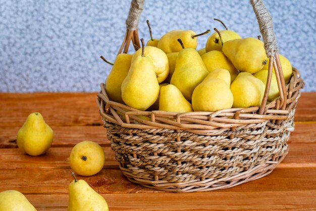 Basket with ripe juicy yellow dream pears closeup wooden table