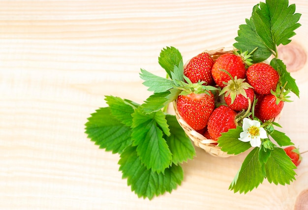 basket with strawberries on a wooden surface View from above