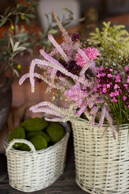 Basket with wildflowers. Summer violet flowers in straw basket.