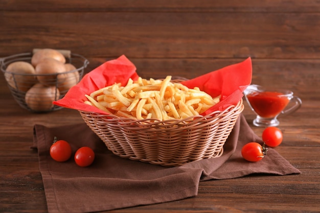 Basket with yummy french fries on table