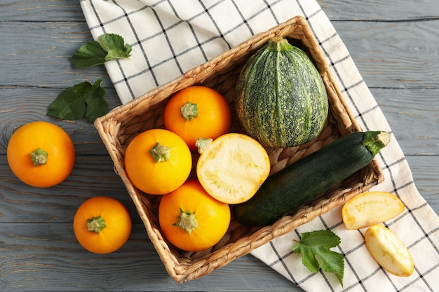 Basket with zucchini on napkin on wooden table