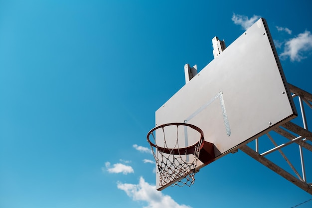 Basketbal hoepel in zonnige dag op de achtergrond van de blauwe lucht Ruimte kopiëren
