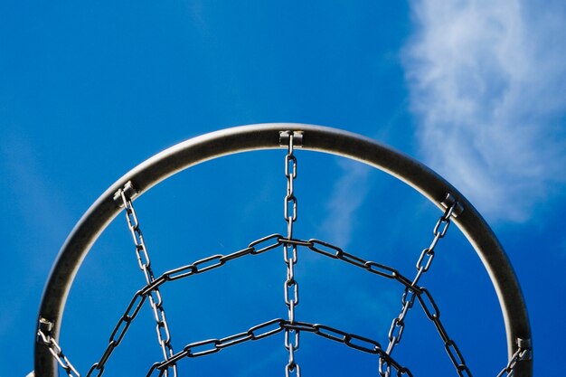 Basketbal hoepel met metalen net en blauwe lucht op straat