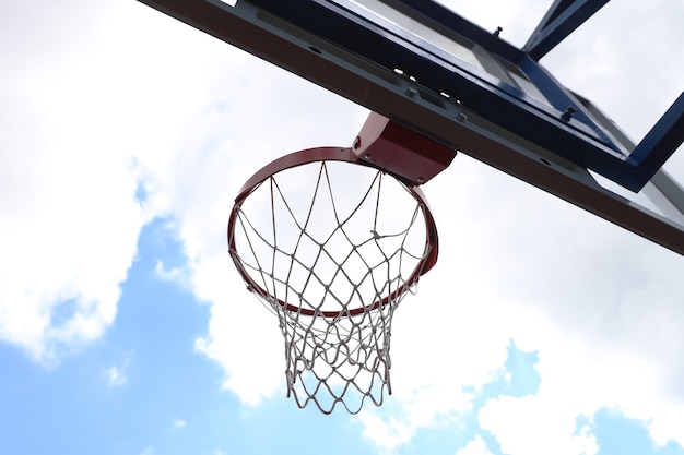 Basketbal hoepel op een straat basketbalveld over blauwe lucht in de wolken