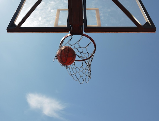 Basketbal zwiept door de hoepel en kijkt van onderaf