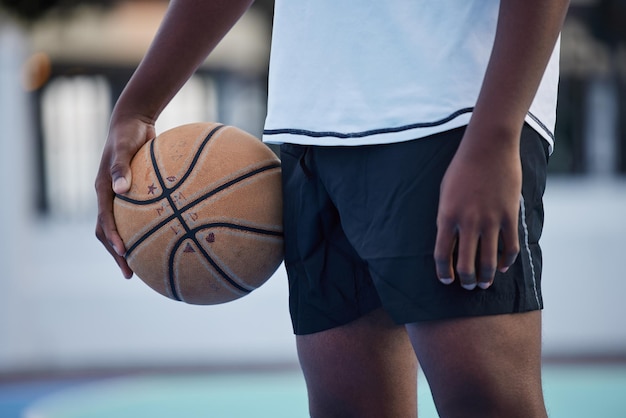 Basketbalatleet klaar voor trainingsspel en competitie op sportveld van onderen buiten Trainingsfocus en fitnesstraining zwarte man met motivatie-mentaliteit en doel om cardio te spelen en te winnen