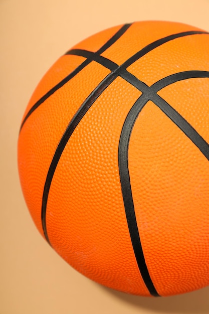 Баскетбольный мяч на бежевом фоне концепции мячей