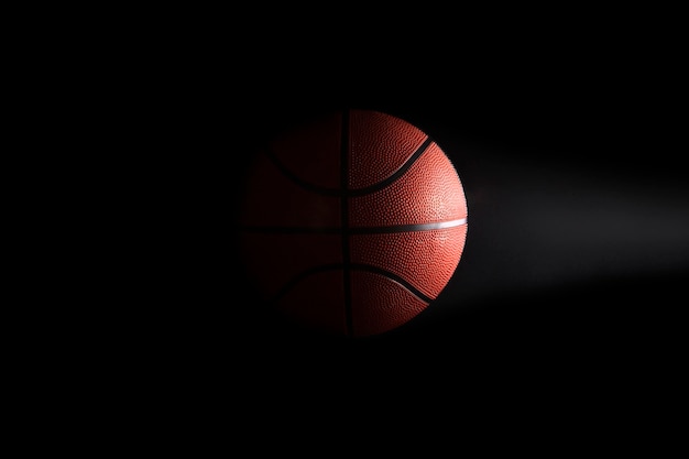 Basketball on black background in the dark with blank space