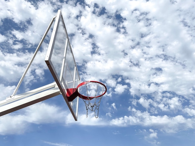 A basketball court, a basket ring hoop against the sky