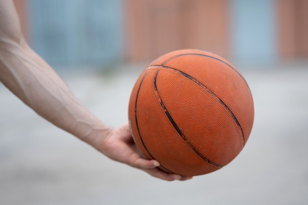 Un pallone da basket in mano per strada