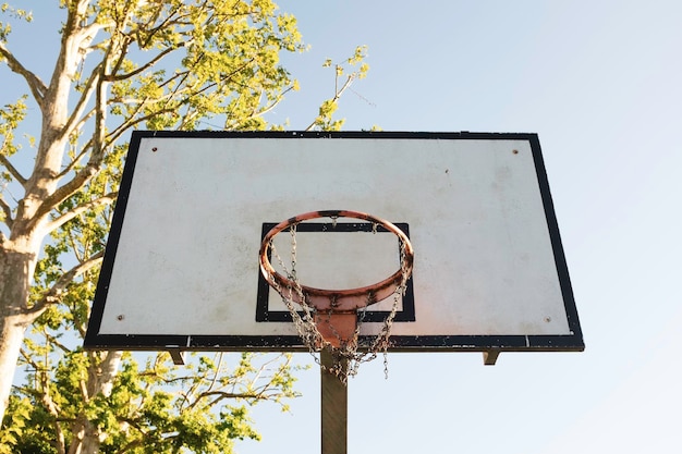 Basketball hoop against a blue sky in sunny day vintage\
basketball hoop with a backboard metal basketball hoop lifestyle\
object for sport on the street city concept of reaching the\
goal