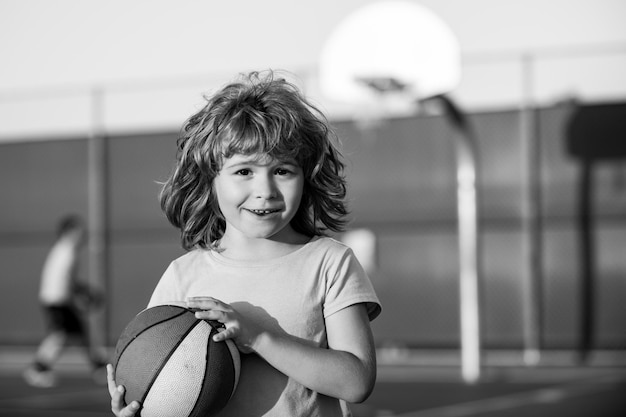 Basketball kids game Portrait of cute little boy holding a basketball ball trying make a score