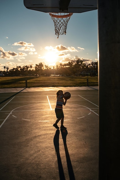 Basketball kids training game on silhouette sunset