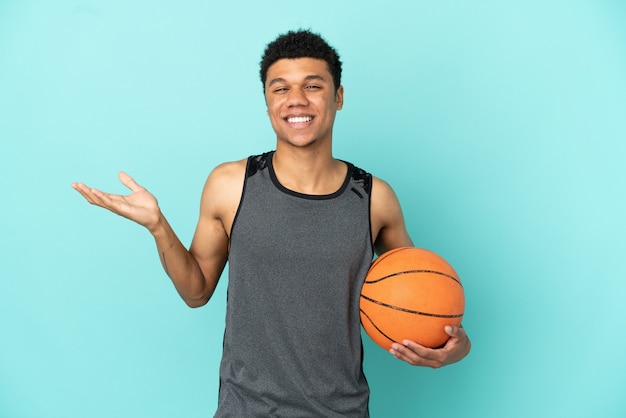 Basketball player African American man isolated on blue background with shocked facial expression