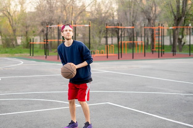 Basketball player doing practice shooting drills outdoor in the city street courts