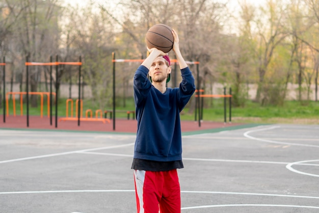 Basketball player doing practice shooting drills outdoor in the city street courts