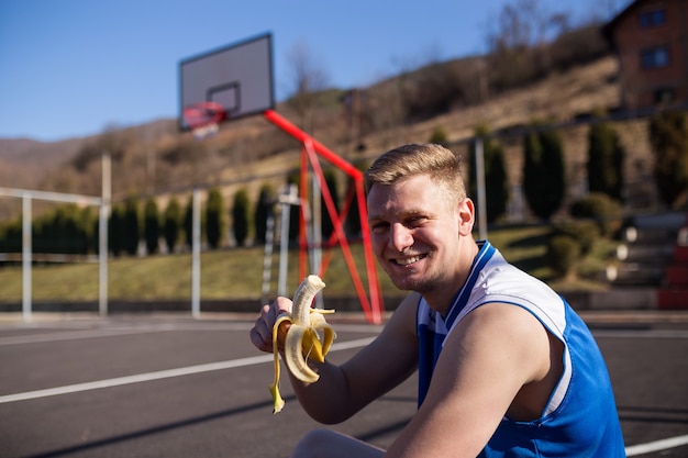 Foto giocatore di basket che mangia banana