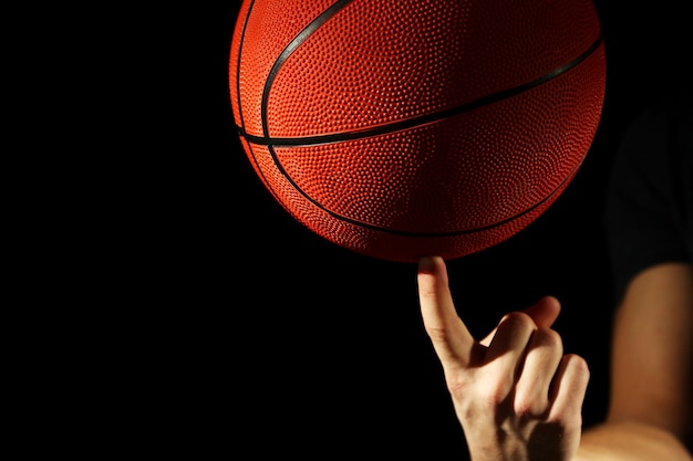 Basketball player holding ball on dark background