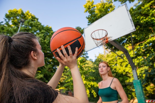 A basketball player is about to shoot and the other girl is defending during a game