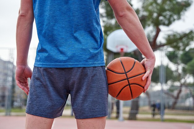 Basketball player looking at the basket before throwing young man with the ball and sportswear