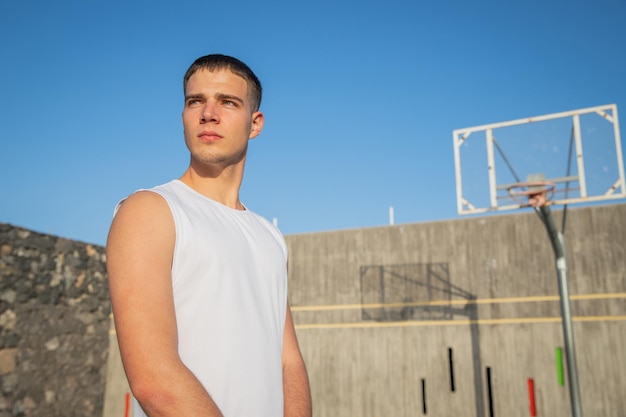 A basketball player looks ahead with an ambitious and confident gaze while at the court