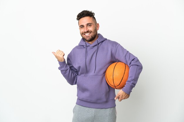 Basketball player man isolated on white background pointing to the side to present a product