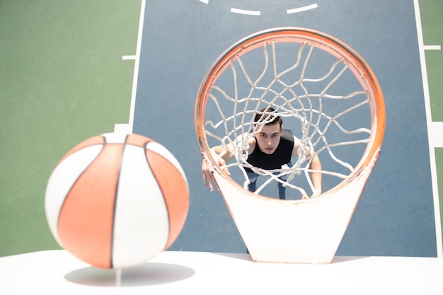 Basketball player sports and basketball man jumps and throws a\
ball into the basket