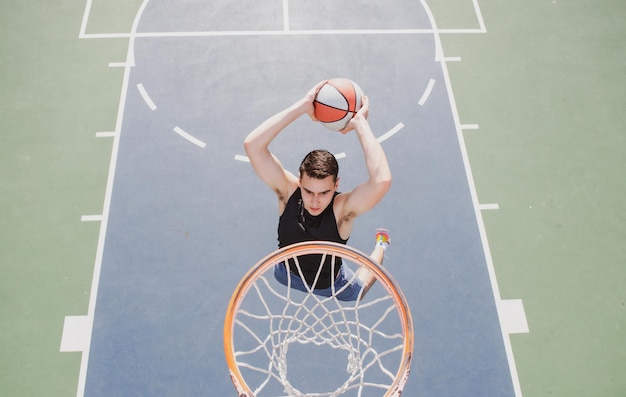 Basketball player sports and basketball man jumps and throws a\
ball into the basket