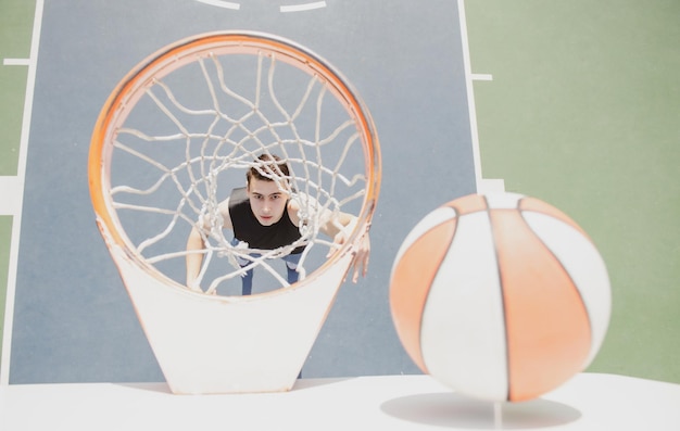 Foto giocatore di basket sport e basket un giovane salta e lancia una palla nel cielo blu del canestro