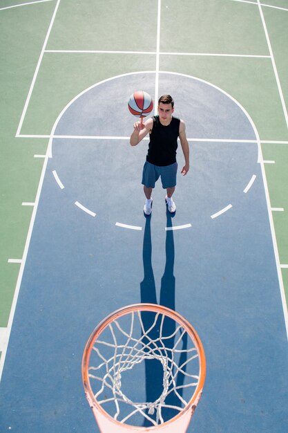 バスケットボールを撃っている男のフープの上にバスケットボールをしているバスケットボール選手の上面図