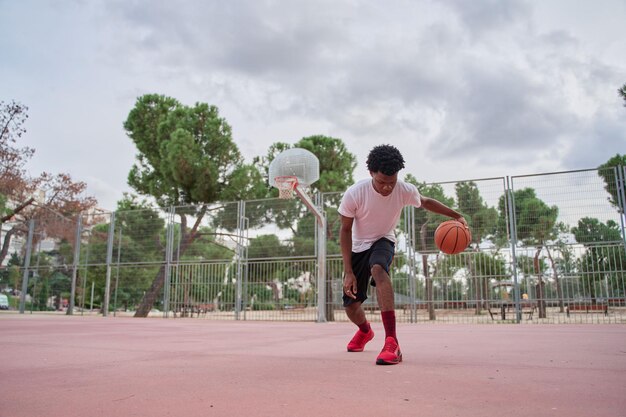 Баскетболист тренируется на корте в городе