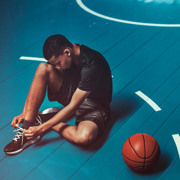 Photo basketball player tying his shoelaces