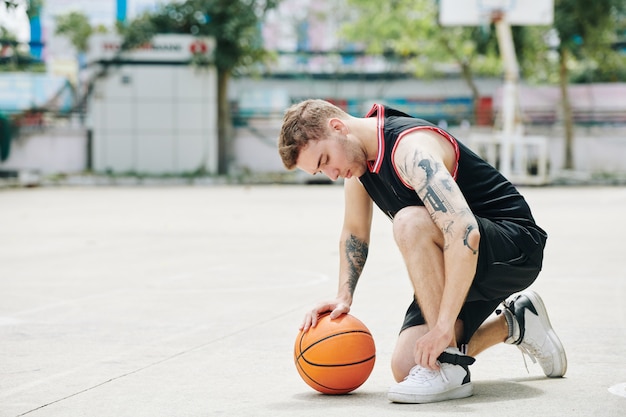 Basketball player tying shoes