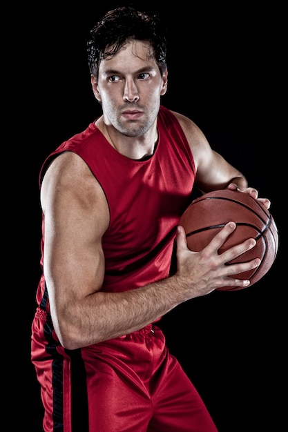 Basketball player with a ball in his hands and a red uniform. 