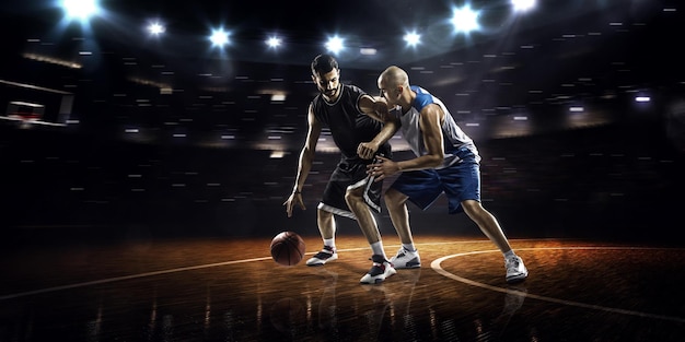 Basketball players on a court with lights in the background