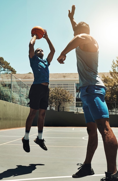 写真 バスケットボールのスポーツゲームと、屋外のバスケットボールコートでのゴールフィットネスエクササイズとトレーニングトレーニングのために撮影する男性ストリートコンペの勝者の考え方と健康なアスリートのジャンプと試合