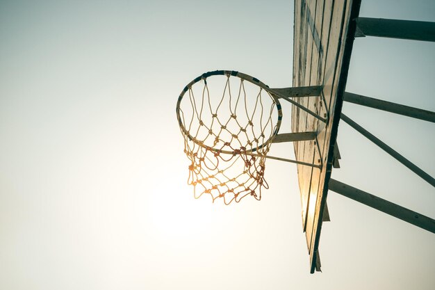 Basketbalring in zonlicht en lucht / voor doelconcept