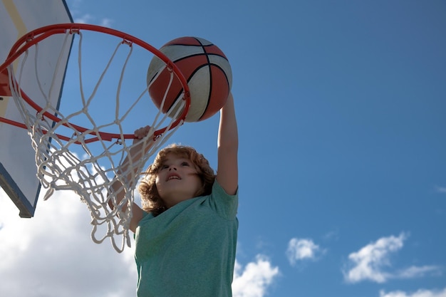 Basketbalspeler die naar boven rent en de bal dunkt