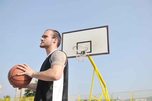 basketbalspeler die oefent en poseert voor basketbal en sportatleetconcept