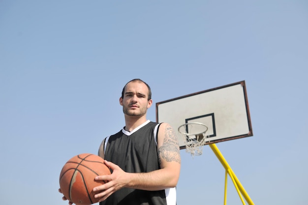 basketbalspeler die oefent en poseert voor basketbal en sportatleetconcept