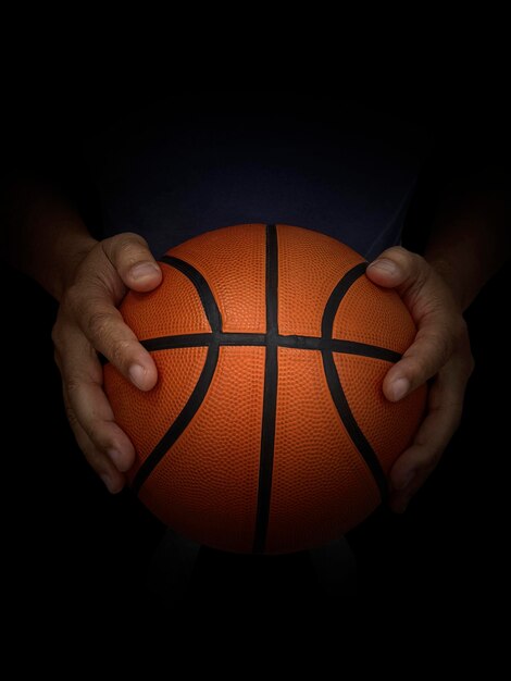 Foto basketbalspeler met een bal tegen een zwarte achtergrond